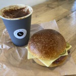 Cappuccino and pastrami & Swiss cheese roll at Otis & Belle bakery in Moreton-in-Marsh